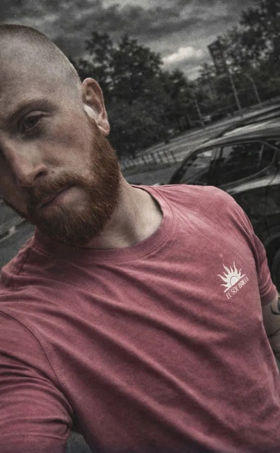 Sebastian, en man med rött skägg och tatuerad arm, fotograferad utomhus en molnig dag